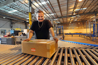 Man placing box on shipping conveyor belt