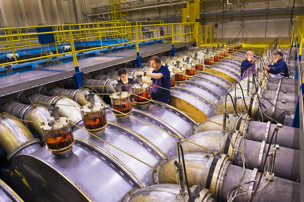 The linear Hermes pulsed power machine — the most powerful gamma ray producer in the world — is serviced for its next shot by technicians. Because of Sandia's nuclear responsibilities, Hermes and Saturn are kept in "warm standby mode" for immediate testing of components
