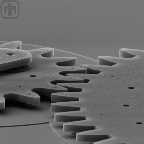 Side view of a microengine drive gear meshed with another gear.