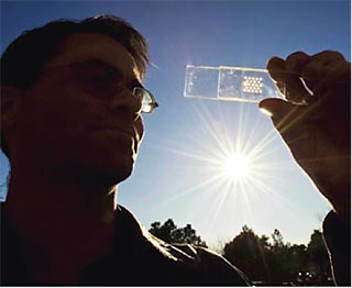 Photo of LDRD researcher holding a solar cell test prototype