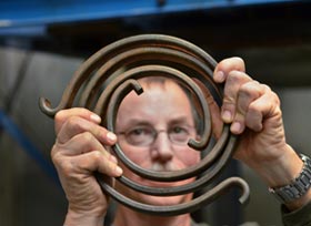 Elton Wright shows a torsional spring used to simulate the rotational vibration of the drill string in a Sandia experiment.