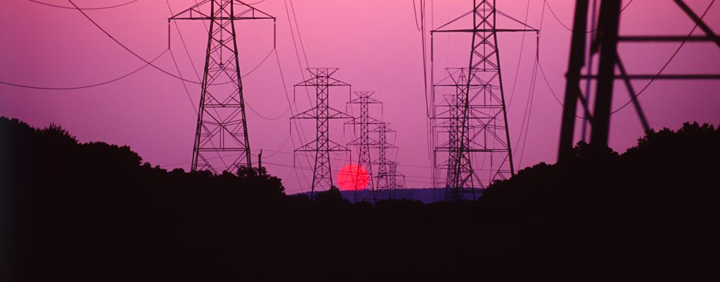 Multiple electric lines are shown in front of a sunset