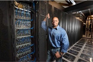 Engineer standing in front of a computer newtork at the Center for Computing Research (CCR)