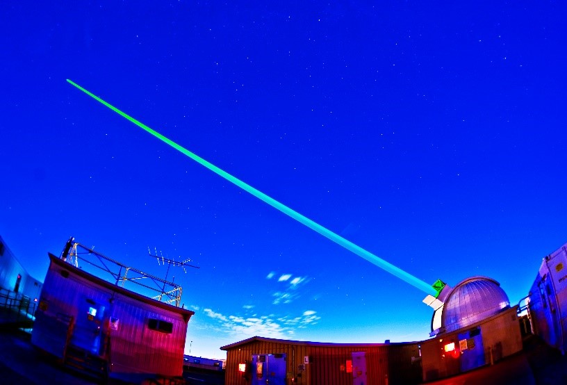 High-powered laser directed at the sky at dusk