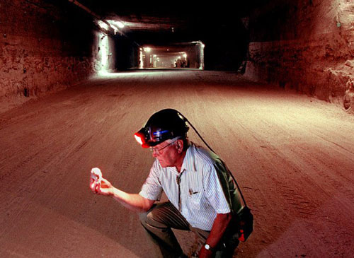 Researcher observing rock material at the WIPP site.