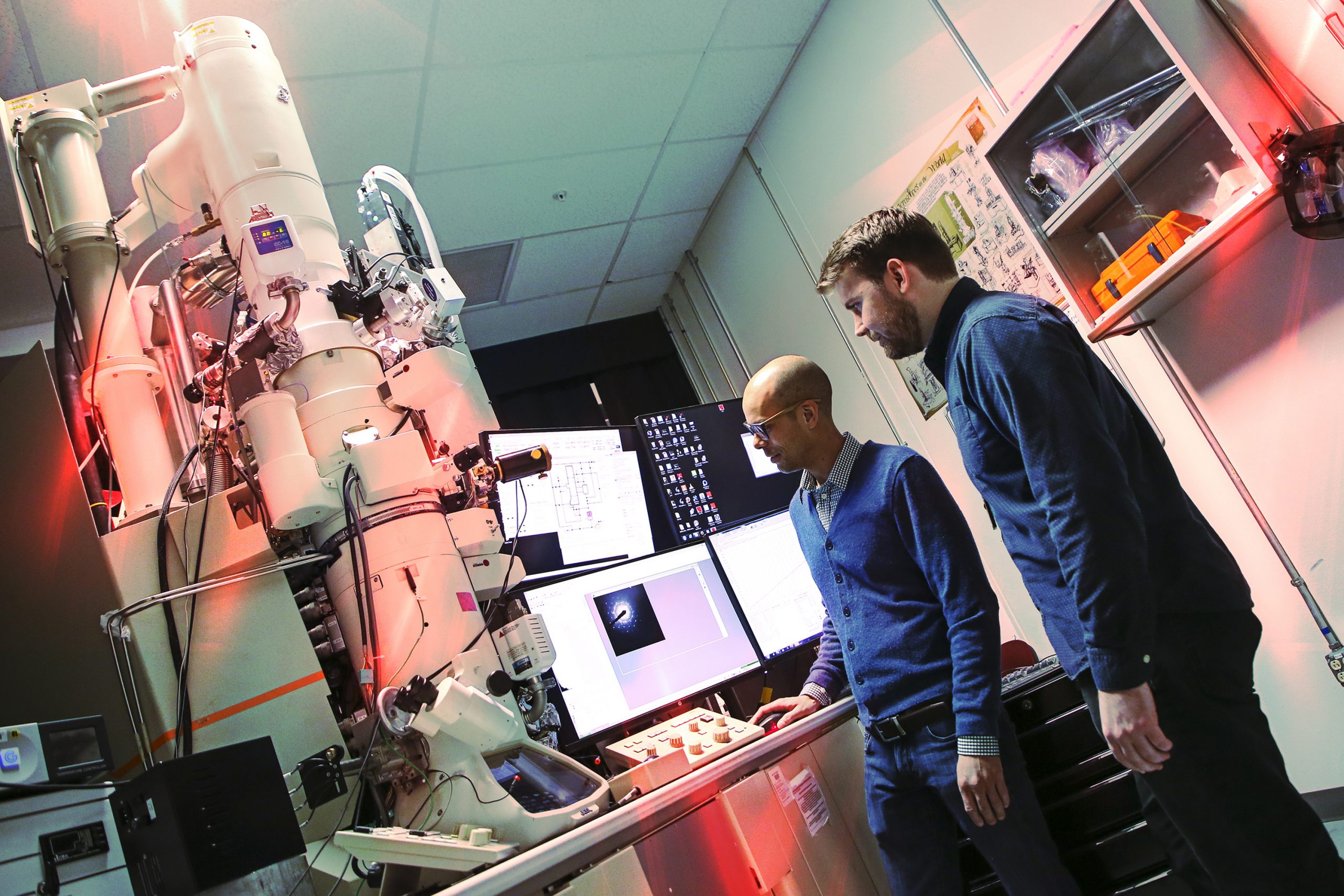 Sandia researchers operate an electron microscope to study atomic-scale radiation effects on metal.