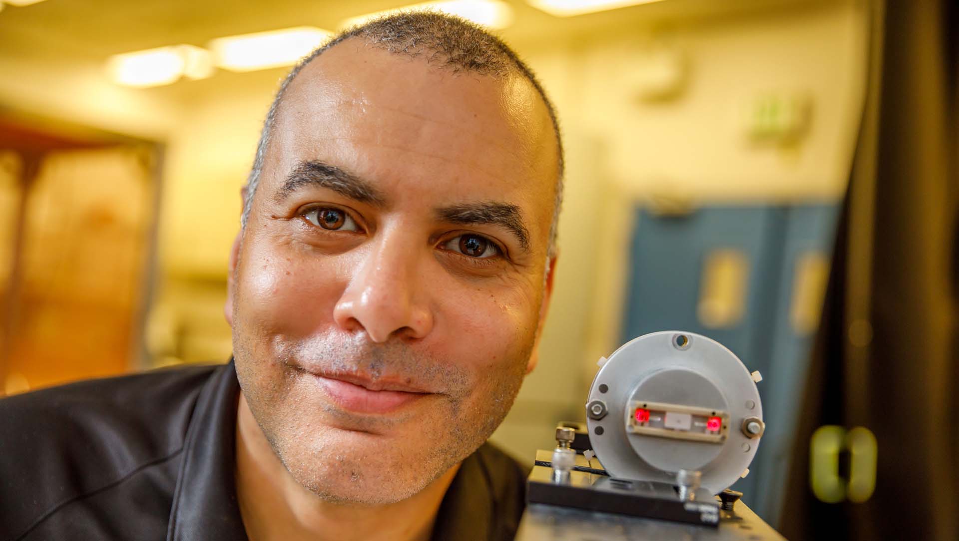 A Sandia researcher holds an optical sensor to measure high voltages.