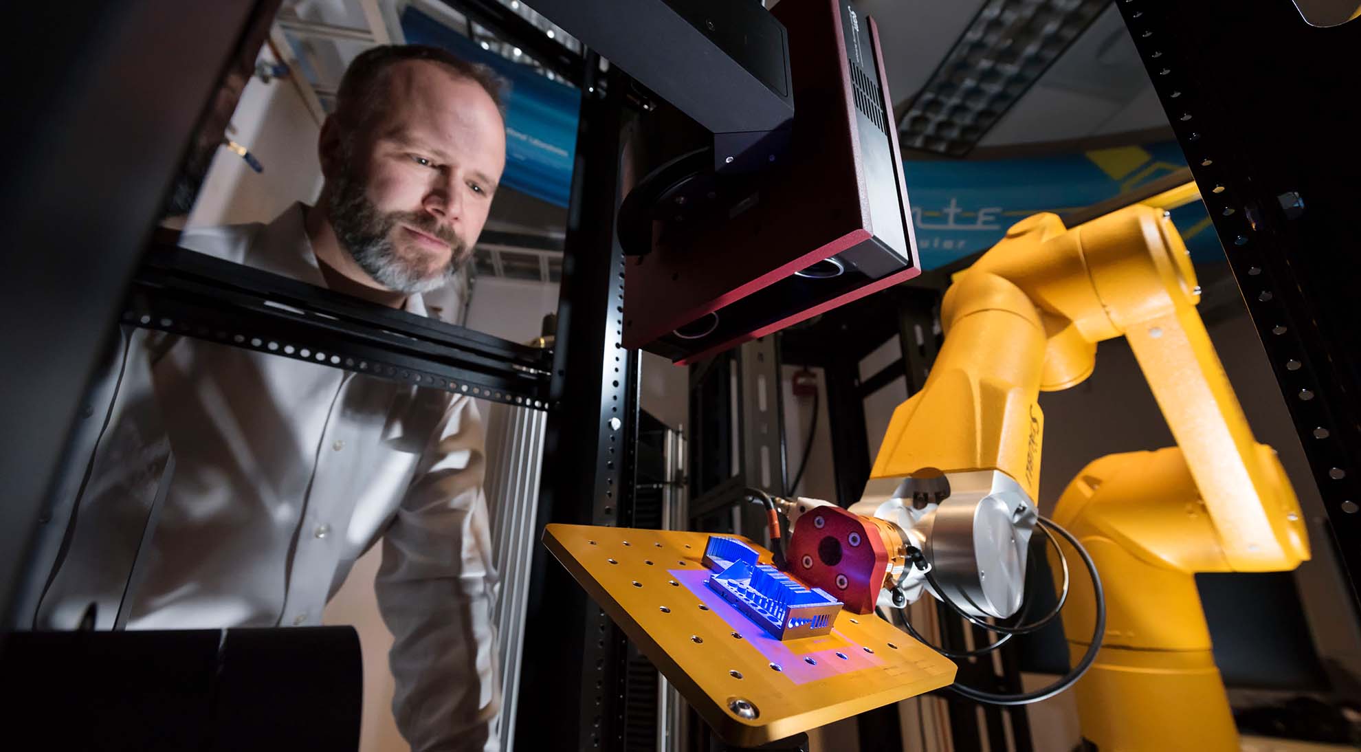 Sandia material scientist watches as a 3D-printed part is scanned