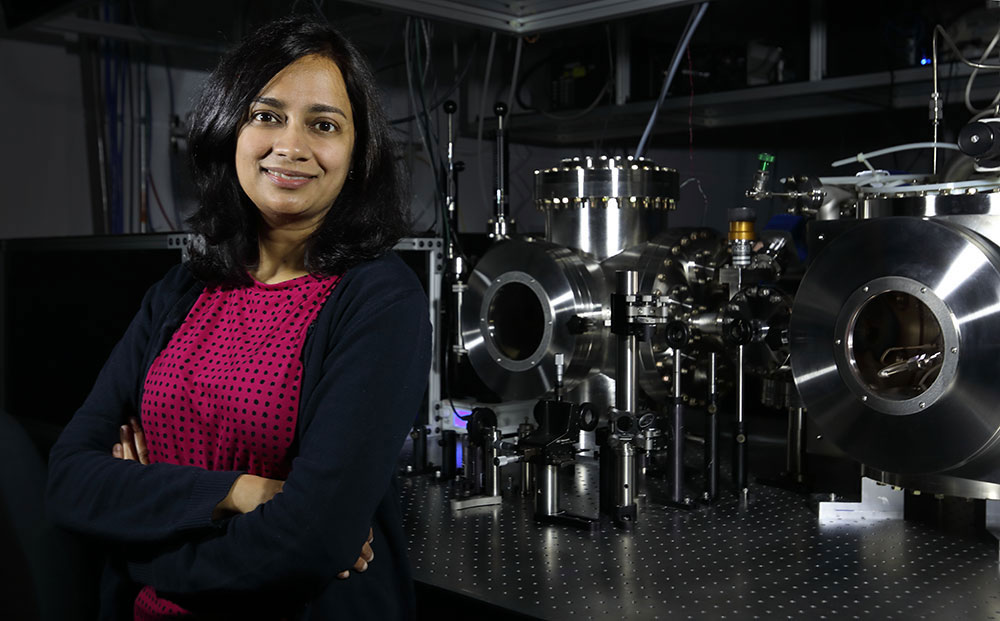 Krupa Ramasesha, a Sandia researcher, in front of a laser
