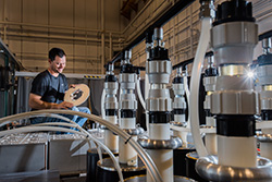 Sandia Labs technologist Joshua Usher loads a target into the main power flow section of Veloce, a Sandia pulsed-power generator. The machine uses pressure to fabricate nanoparticles into nanowire-array structures similar to those that underlie the surfaces of touch-screens for sensors, computers, phones and TVs. The pressure-based process takes nanoseconds. Chemistry-based industrial techniques take hours. Learn more atbit.ly/2pjlI76. Photo by Randy Montoya.