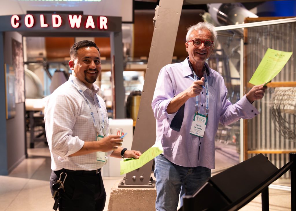Felipe Palacios II and Valerio DeAngelis (Sandia National Laboratories) compete to complete a scavenger hunt at the National Museum of Nuclear Science and History during a networking reception held following the 2026 Energy Storage Systems Safety & Reliability Forum. / Credit: Alicia Bustillos, Sandia National Laboratories