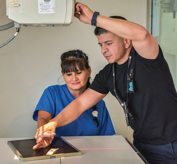medical caregiver takes x-ray of patient's arm