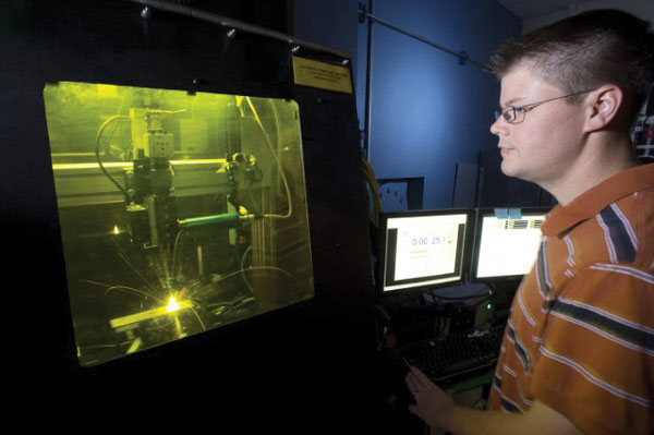 Cody Love laser welds an explosive component.