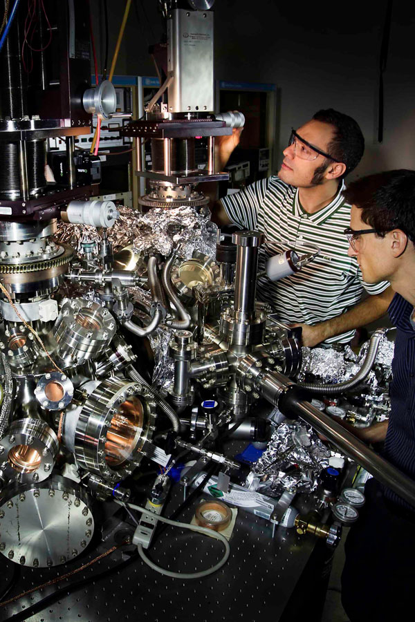 researchers work on complex machinery