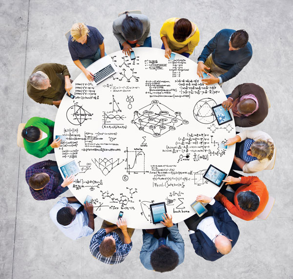 group sitting at a table scribbled with mathematical drawings