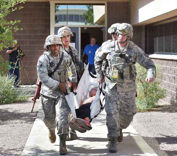emergency management team carries mock victim during drill