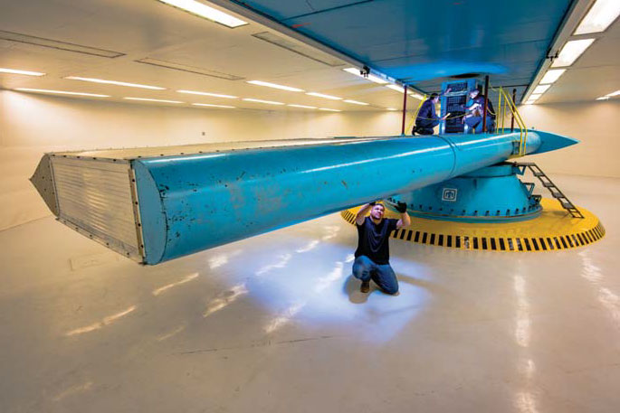 SANDIA’S CENTRIFUGE TEST COMPLEX simulates weapon system launch and re-entry environments including acceleration, deceleration, and vibration. Glenn Yarborough inspects the centrifuge arm, while Orlando Abeyta (left) and Ed Romero work above. (Photo by Randy Montoya)