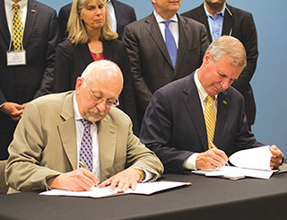 Sandia President and Laboratories Director Paul Hommert and Georgia Tech President G. P. “Bud” Peterson sign a five-year memorandum of understanding at the Centergy Building on the Georgia Tech campus. The MOU establishes a strategic collaboration that seeks to solve science and technology problems of national importance. Behind Paul is Div. 6000 VP Jill Hruby, who will become Sandia president and Labs director on July 17. Jill developed many of the current collaborative programs with Georgia Tech.