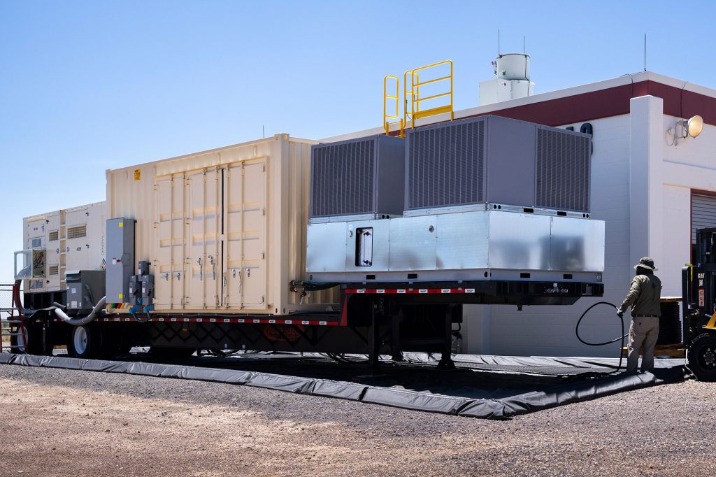 An engineer powers six-degree-of-freedom shakers, housed on the right, with cable from the mobile infrastructure unit.