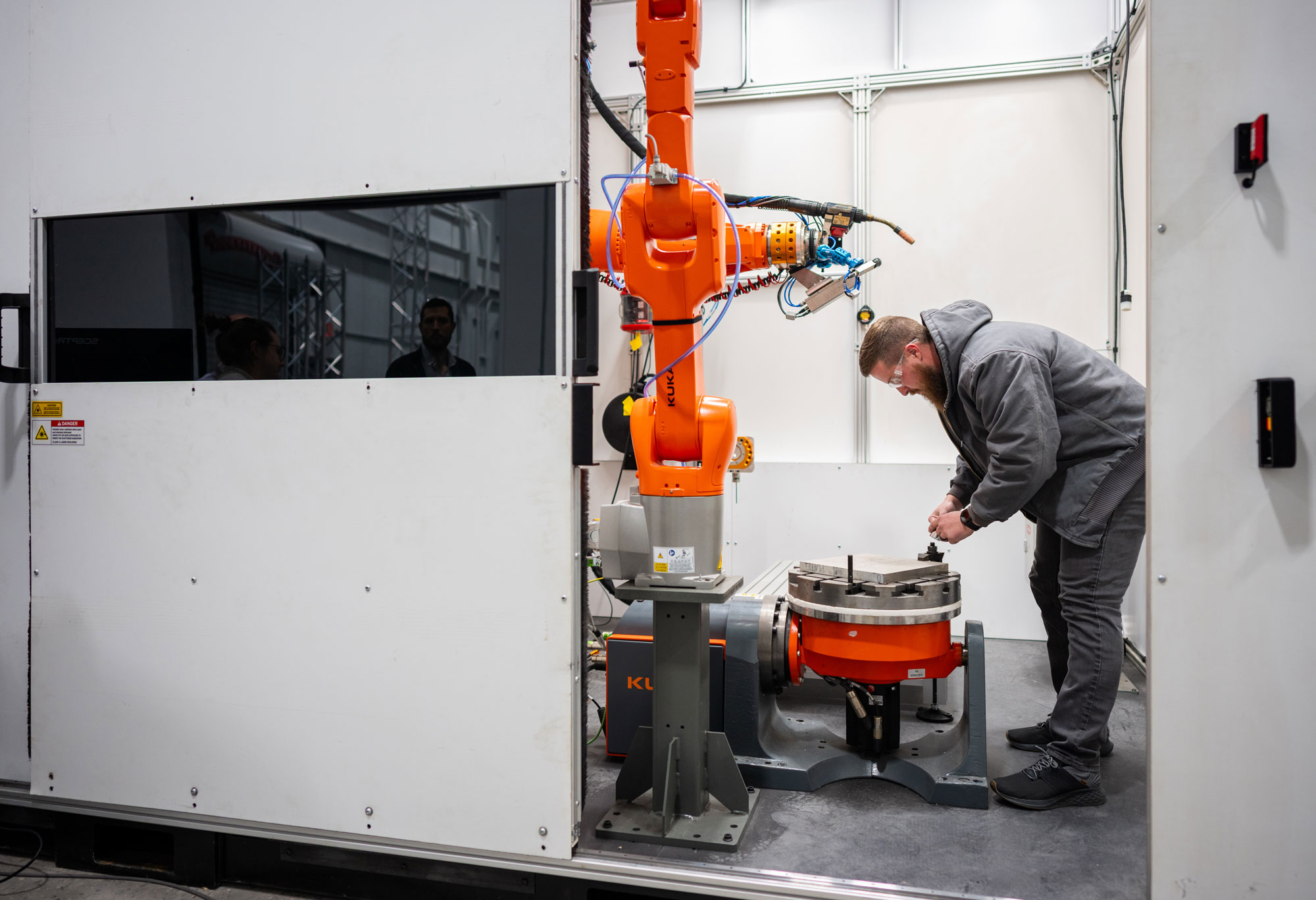 A technologist installs a new base plate on a system for additive manufacturing at CAMINO.