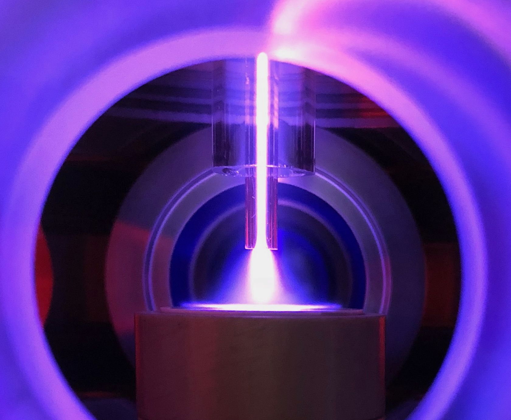 Atmospheric Jet laser displaying colors of purple within a metal cylinder