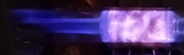 Purple colored plasma coming from a smaller tube to the left and culminating in a lighter swirl of plasma to the right in a larger tube shape.