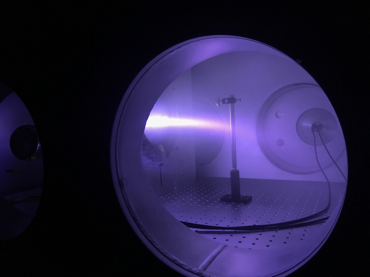 Looking at a laser through a cylinder viewpoint, purple in color, laser pointing from source to the left