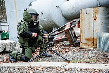 Man in heavy armor inspecting equipment