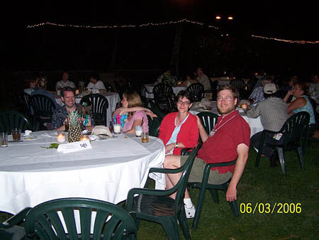 Participants sitting outside at a dining table at night
