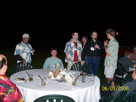 Participants outside standing and conversating around a dining table at night