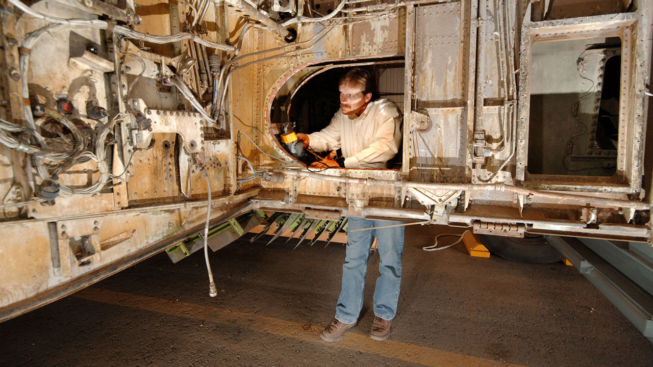 Man inspecting damaged airplane