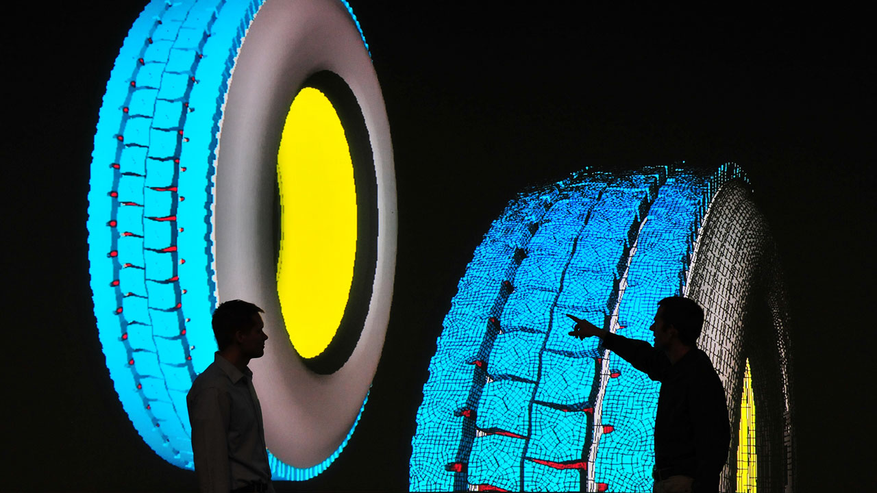 Men looking at computer simulation of tires. Tire imaging is very large.