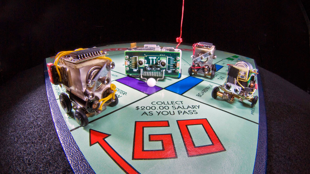 Miniature autonomous robotic vehicles on a board game.