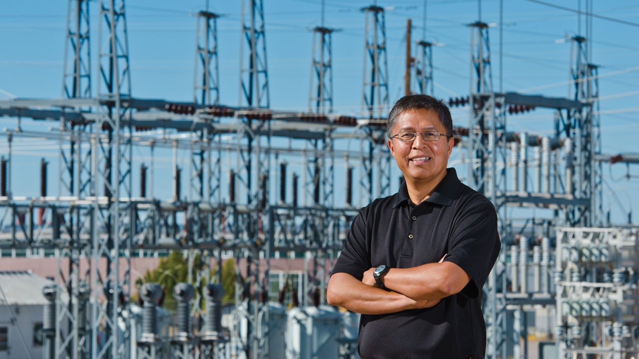 Man standing in front of transformer with his arms crossed.