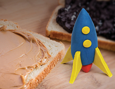 Peanut butter and jelly sandwich next to a toy rocket