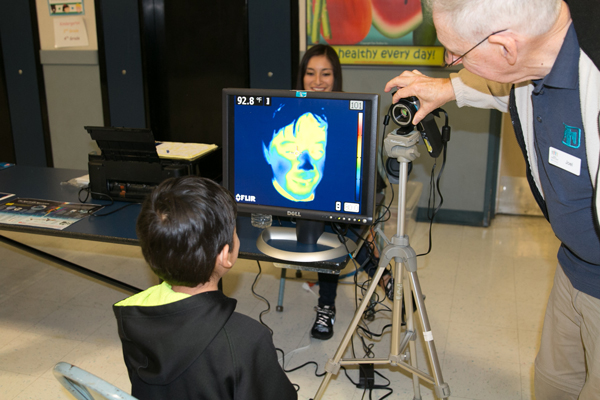 Child looking at a 3D computer image of himself