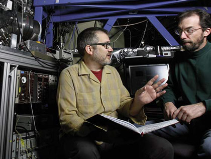 Combustion researchers Craig Taatjes & David Osborn sit next to apparatus used in detection and measurement of Criegee intermediate reactions