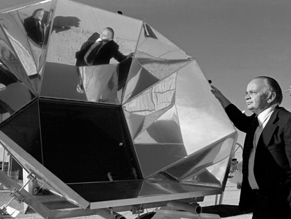 Sandia energy coordinator Don Shuster next to an early solar energy collector design, 1973