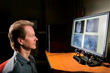 Sandia Researcher Mike Haass demonstrates how an eye tracker under a computer monitor is calibrated to capture his eye movements on the screen.