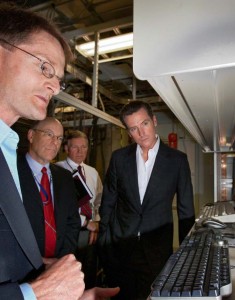 Image of Chuck Mueller (left) shows Gavin Newsom (right) a high-speed movie of a new fuel-injection strategy.