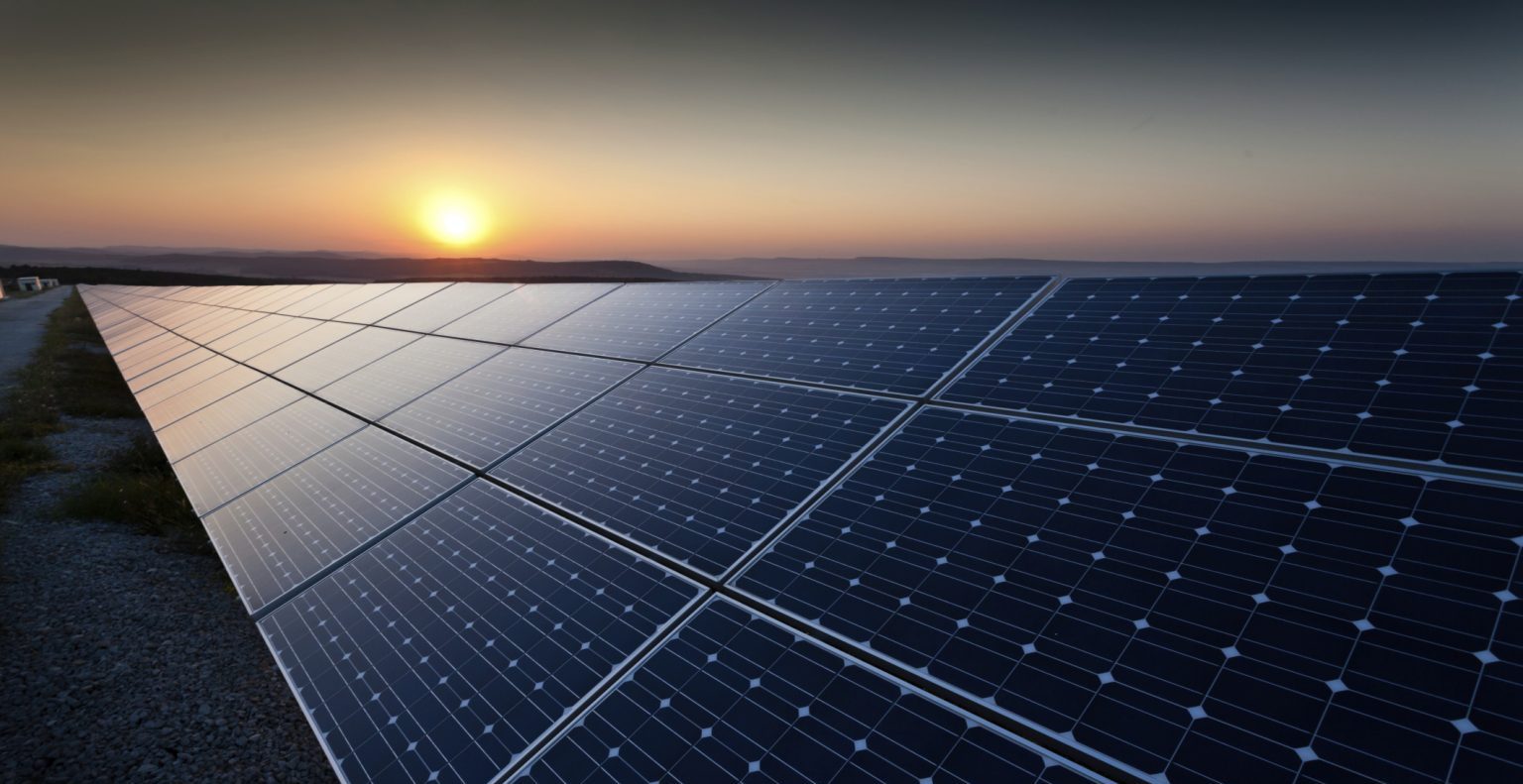 PV panels shine in the setting sun at a photovoltaic farm.