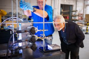 Sal Rodriguez, right, looks on in amazement as technologist Robin Sharpe injects dye into the dimpled model they built, showing the way dimples increase heat transfer in water