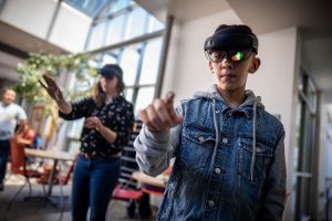 Student Christian Martinez, right, explores his surroundings through augmented reality glasses during a demonstration at Sandia National Laboratories. 