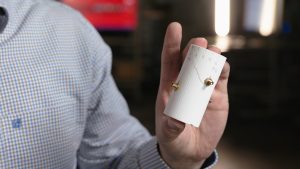 Man holding a white cylinder.