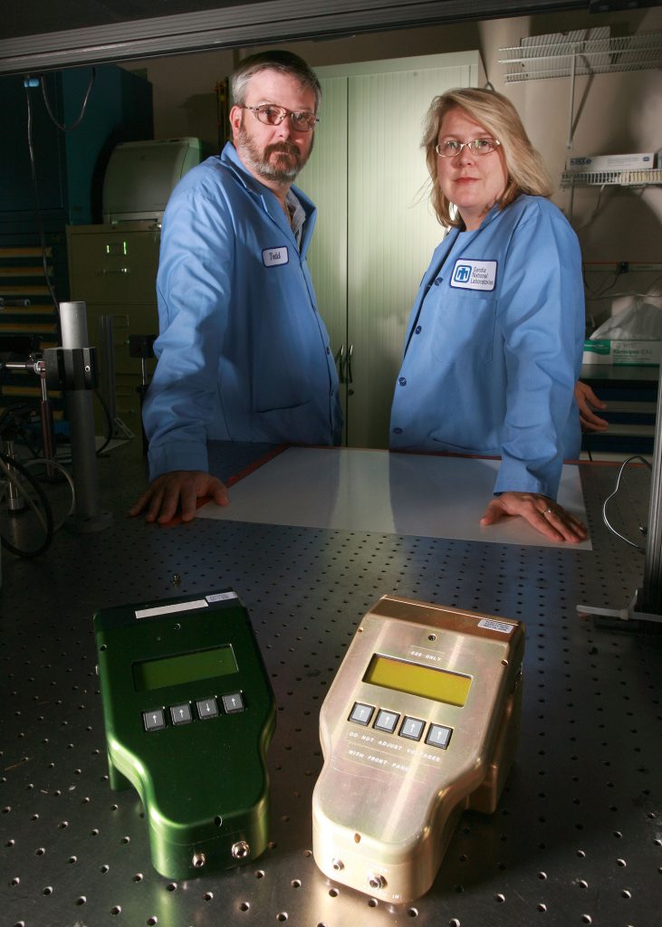 Sandia researchers Todd Lane (left) and Victoria VanderNoot (right) are leading an effort, funded by the National Oceanic and Atmospheric Administration (NOAA) and the University of New Hampshire, to detect deadly toxins from HABs. The project employs laser-induced fluorescence and other separation methods inherent in Sandia’s µChemLab™ device, examples of which are seen here.