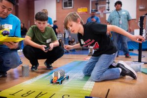 Pablo Sandoval, right, and Tomas Giron, students from Jefferson Middle School in Albuquerque, let their car loose under the watchful eye of Sandia National Laboratories' volunteer Justin Teo during the New Mexico Electric Car Challenge on Nov. 15. (Photo by Craig Fritz) Click on the thumbnail for a high-resolution image.