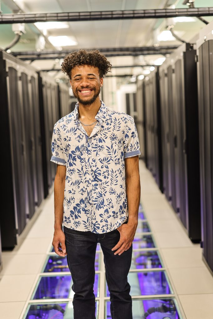 Male intern standing in hallway of High Performance Computers.