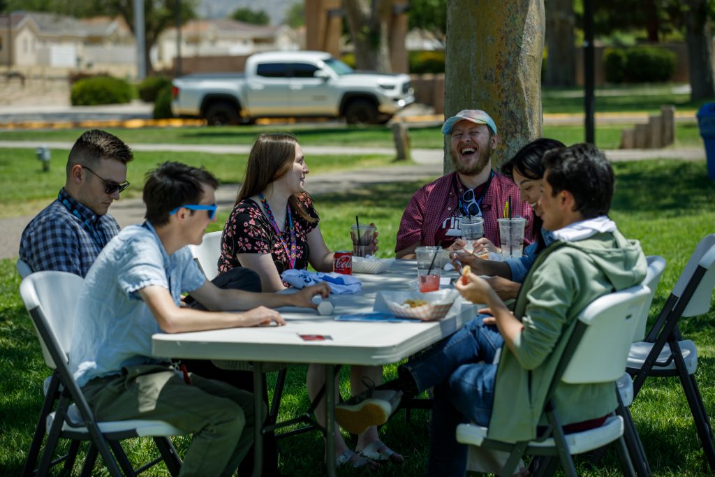 Interns eating together laughing during Sandia Welcome Event