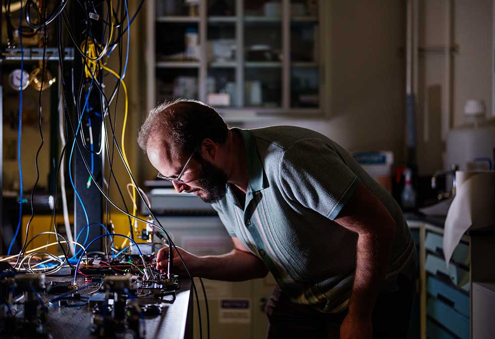 OPTICAL PRECISION — Truman Fellow Dan Herman fine-tunes the current for an optical amplifier within an electro-optical frequency comb system. (Photo by Craig Fritz)