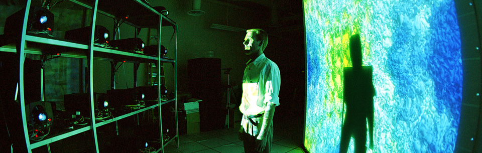 man viewing bank of projectors showing modelling image on screen